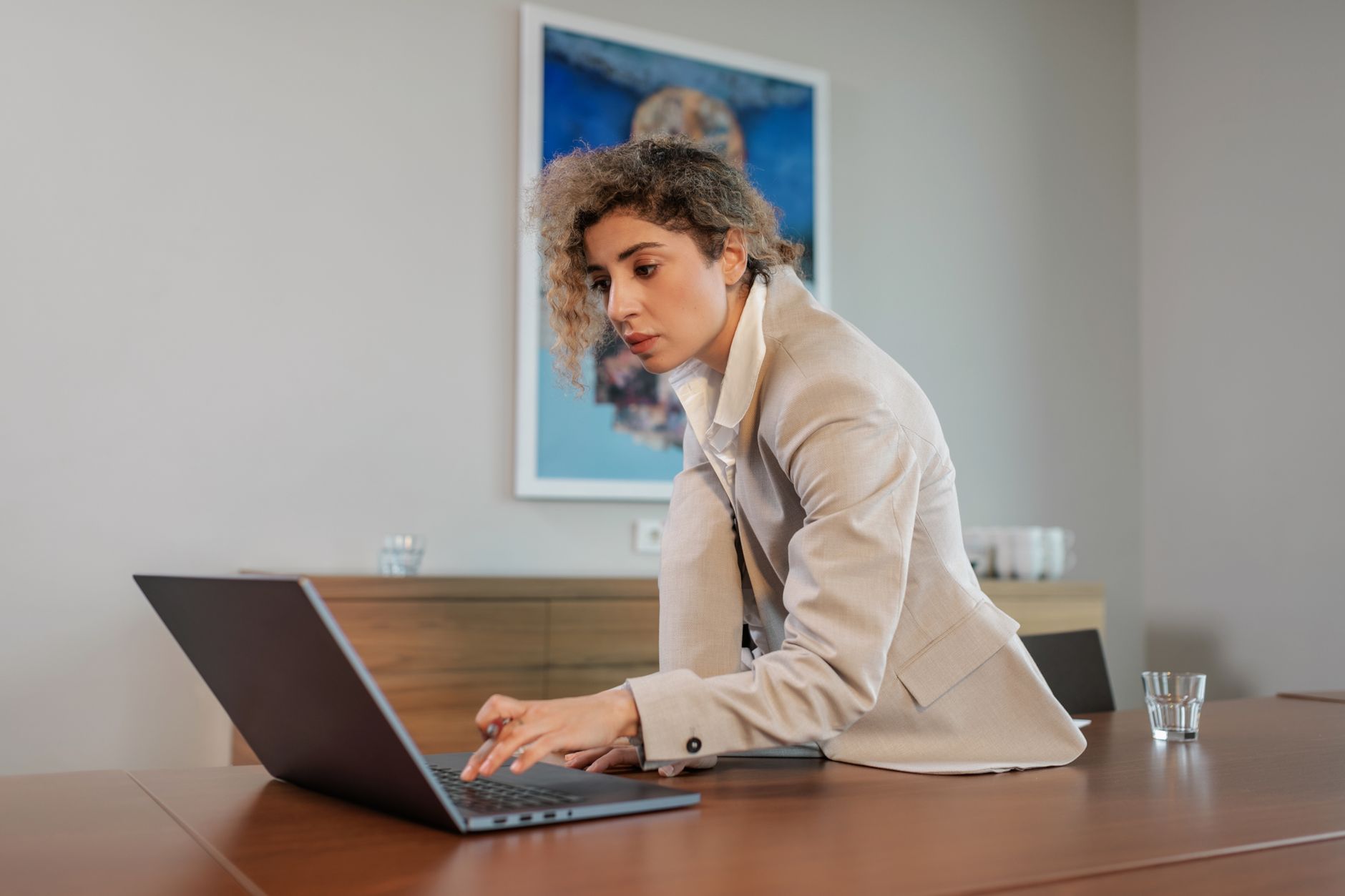 Funcionária da área financeira usando laptop em escritório, contexto de adoção de ferramentas de IA sem homologação